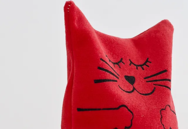 Kissekatt, gosedjur, finns oftast i flera färger. Bomullsvelour med fyllning av hirsagnar. Design och handtryck Ann Eriksson, SALT Konsthantverk.